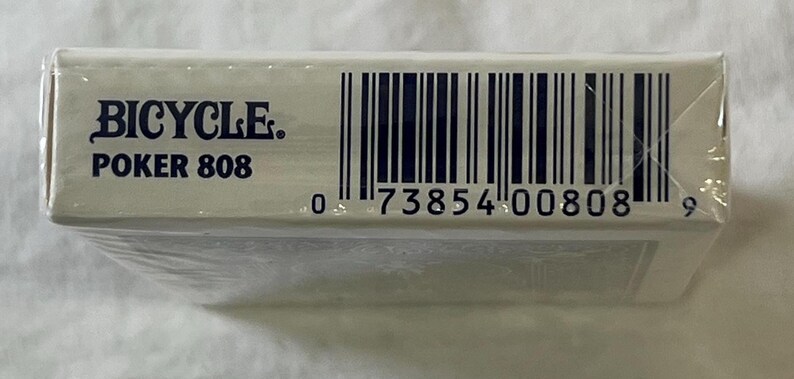 May include: A sealed deck of Bicycle Poker 808 playing cards. The white box features the brand name and product information in blue text, along with a barcode. The deck is wrapped in clear plastic.