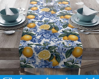 May include: A white table runner with a lemon and blue floral pattern. The runner is on a wooden table with blue and white dishes and glasses.