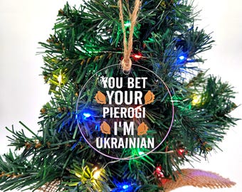 May include: A clear round Christmas bauble with the text "You bet your pierogi I'm Ukrainian" and a brown string hanger.