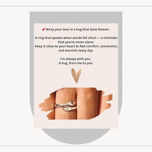 Könnte beinhalten: Ein silberner Ring mit einem Design aus sich umarmenden Händen. Der Ring wird an einem Finger gezeigt, wobei die Hände den Finger umarmen. Das Bild enthält den Text: "Wrap your love in a hug that lasts forever."