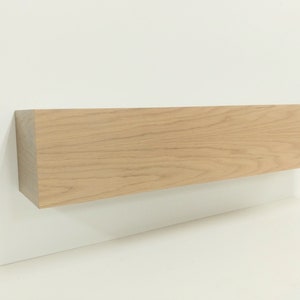 May include: A light wood shelf with a natural finish. The shelf is rectangular and has a smooth surface.