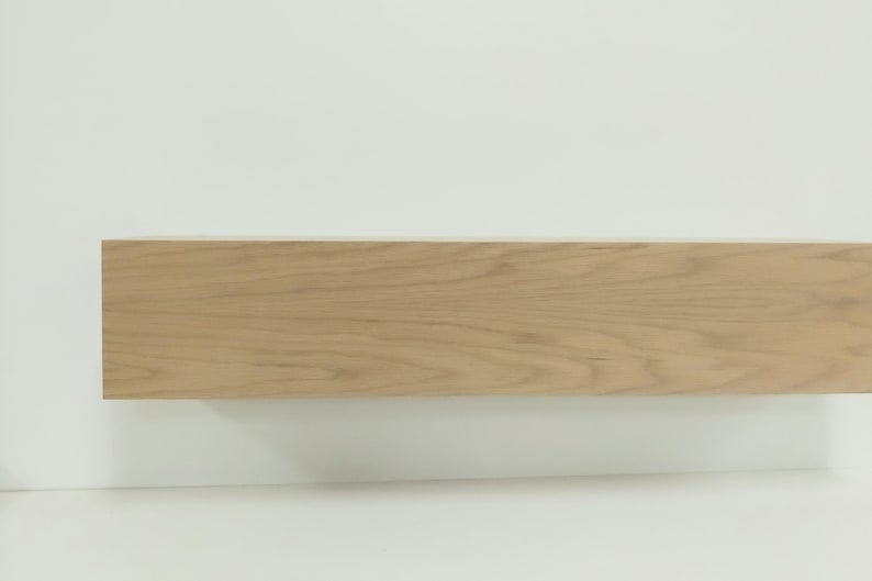 May include: A light wood shelf with a smooth, natural finish. The shelf is rectangular and has a simple, modern design.