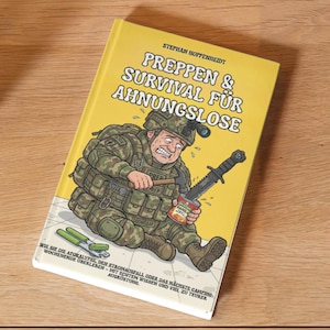 Könnte beinhalten: Ein gelbes Buch mit dem Titel "PREPPEN & SURVIVAL FÜR AHNUNGSLOSE" mit einer Illustration eines Soldaten. Das Buch liegt auf einer Holzoberfläche neben einer Vase mit Trockenblumen und einem Bett.
