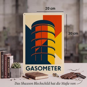 Könnte beinhalten: Ein rechteckiges Metallschild mit einer grafischen Darstellung eines Gasometers in Marineblau, Orange und Gelb. Der Text GASOMETER ist unten aufgedruckt. Das Schild misst 20 cm mal 30 cm, wie durch die sichtbaren Maßlinien angezeigt.