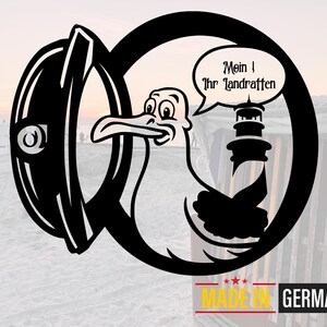 May include: Black and white illustration of a cartoon bird holding a lighthouse with the text "Mein ! Ihr Landratten" in a speech bubble. The image is framed in a circle with the text "MADE IN GERMANY" below.