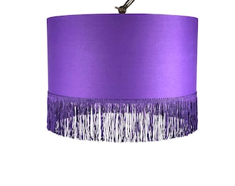 May include: Purple lampshade with a fringe trim.