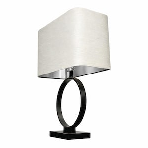 May include: A modern table lamp with a rectangular white shade and a silver interior. The lamp features a black, circular base and a square base. The lamp is designed for indoor use and provides ambient lighting.