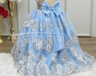 Abito da principessa blu con pizzo argentato, lungo strascico e accessorio per capelli.