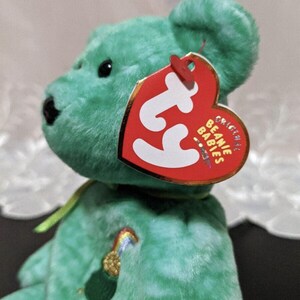 Peut inclure: Ours en peluche vert Beanie Baby avec un arc-en-ciel et un pot d'or brod&eacute;s sur sa poitrine. L'ours en peluche a une &eacute;tiquette Ty attach&eacute;e &agrave; son oreille qui indique "Original Beanie Babies".