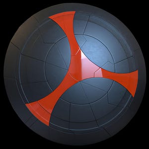 Puede incluir: Un escudo redondo negro con un diseño segmentado y un emblema naranja-rojizo vibrante de tres puntas en el centro. El escudo tiene un brillo metálico y está sobre un fondo negro, lo que le da un aspecto futurista.