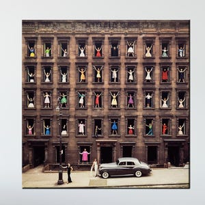 May include: A vintage print shows a multi-storey building with people in colourful outfits waving from windows. A classic car is parked in front, and two figures stand nearby. The artwork has a retro aesthetic.