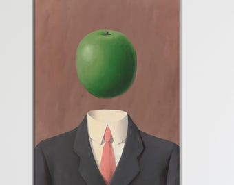May include: A framed print of a surreal artwork. The image features a man in a dark suit, white shirt, and red tie, with a large green apple floating where his head should be. The background is a solid brown color.
