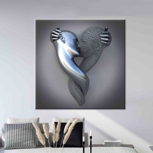 Op de afbeelding: Een grote, metalen sculptuur van twee figuren die elkaar omarmen en een hart vormen. E&eacute;n figuur is glad en zilverkleurig, de andere is getextureerd. Het kunstwerk hangt aan een grijze muur boven een witte bank en salontafel.