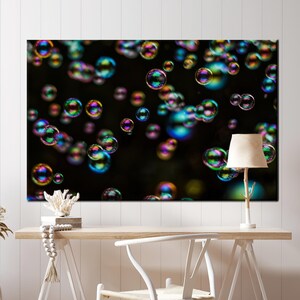 May include: A black background with many iridescent soap bubbles of various sizes floating in the air. The bubbles are reflecting light, creating a rainbow effect.