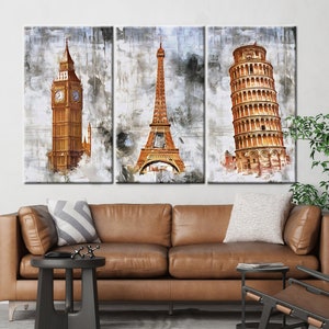May include: Triptych canvas art featuring iconic landmarks: Big Ben, the Eiffel Tower, and the Leaning Tower of Pisa. The artwork has a watercolor effect with shades of gold, brown, and gray. The canvas is stretched and ready to hang.