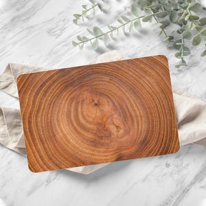 May include: A rectangular wooden cutting board with a natural wood grain pattern. The board has a light brown color and a smooth surface.