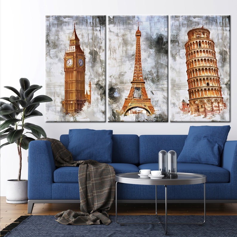 May include: A triptych canvas art set featuring iconic landmarks: Big Ben, the Eiffel Tower, and the Leaning Tower of Pisa. The artwork has a watercolor effect with a neutral background and warm tones. The set is displayed above a blue sofa.