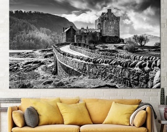 May include: A black and white photograph of a stone castle on a rocky island. The castle is surrounded by a stone wall and a winding road leads up to the castle.