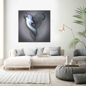 Op de afbeelding: Een modern kunstwerk voor aan de muur met een metalen sculptuur van twee figuren die elkaar omarmen in de vorm van een hart. De sculptuur heeft een gepolijste zilveren afwerking en staat tegen een grijze achtergrond. Het kunstwerk wordt getoond in een moderne woonkamer.