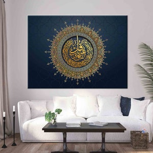 Puede incluir: Gran lienzo art&iacute;stico con caligraf&iacute;a &aacute;rabe dorada en un dise&ntilde;o circular ornamentado. La obra de arte est&aacute; sobre un fondo azul oscuro con un patr&oacute;n geom&eacute;trico. Se exhibe sobre un sof&aacute; blanco en un sal&oacute;n.