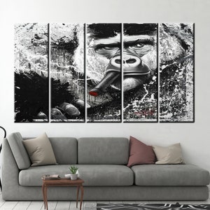 May include: A five-panel canvas art piece featuring a gorilla smoking a cigar. The artwork is primarily black and white with splashes of paint, and a red tip on the cigar. The gorilla's face is detailed, with a serious expression.