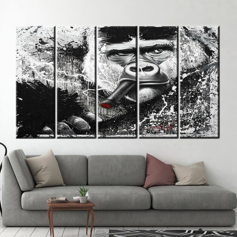 May include: A five-panel canvas art piece featuring a gorilla smoking a cigar. The artwork is primarily black and white with splashes of paint, and a red tip on the cigar. The gorilla's face is detailed, with a serious expression.