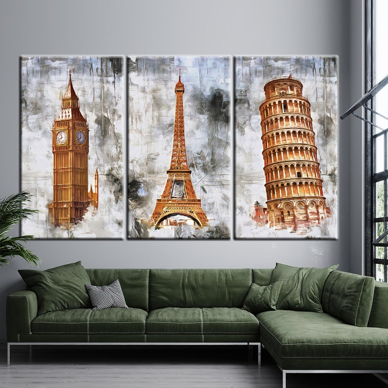 May include: A triptych canvas art print featuring iconic landmarks: Big Ben, the Eiffel Tower, and the Leaning Tower of Pisa. The artwork has a watercolor effect with gold and brown tones against a textured gray background. The canvas is displayed above a green sectional sofa.