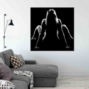 Pu&ograve; includere: Fotografia in bianco e nero di una silhouette di una persona seduta con le gambe incrociate e la testa bassa. Lo sfondo &egrave; nero.