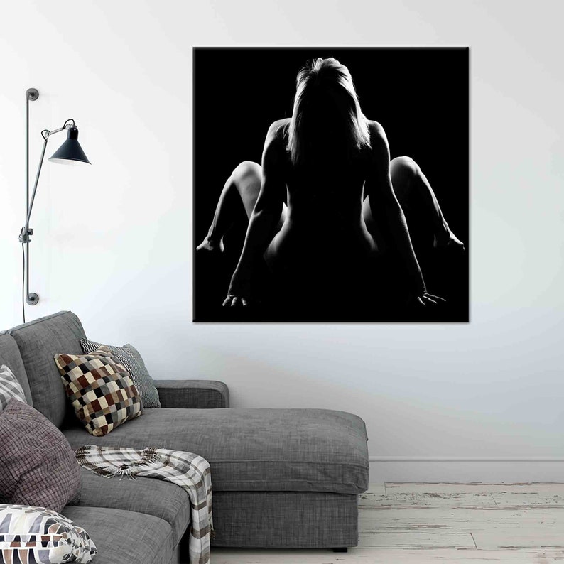 Pu&ograve; includere: Fotografia in bianco e nero di una silhouette di una persona seduta con le gambe incrociate e la testa bassa. Lo sfondo &egrave; nero.