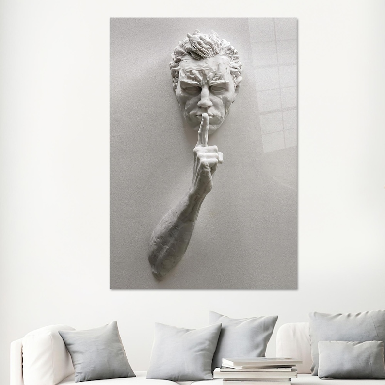 Pu&ograve; includere: Una scultura in gesso bianco di una testa e un braccio di uomo, con l'indice della mano destra alzato alle labbra in un gesto di silenzio.