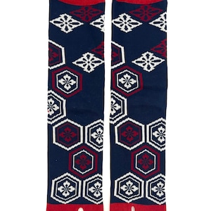 May include: A pair of navy blue tabi socks with a red cuff and toe. The socks feature a repeating pattern of white floral and red geometric designs. The socks are designed to be worn with traditional Japanese footwear.