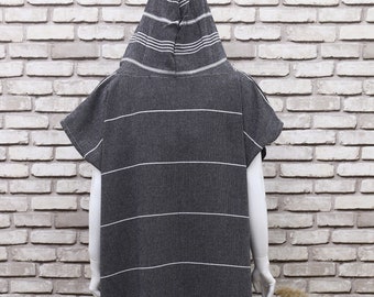 May include: A hooded towel with a striped pattern in black and white. The towel has short sleeves and a fringe at the bottom.