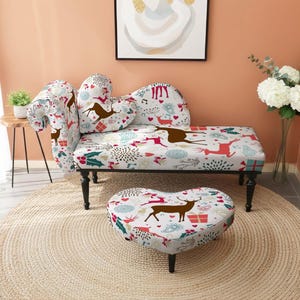 May include: A decorative chaise longue and heart-shaped footstool set. The furniture has a white background with a pattern of brown reindeer, red and green accents, and gift boxes. The set sits on a round, woven rug.