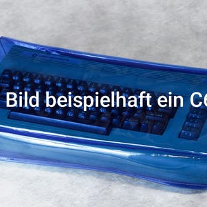 Peut inclure: Un clavier bleu d'ordinateur Commodore 64, protégé par une housse bleue transparente. Le clavier a des touches noires et est présenté sur un fond clair. Le texte de l'image est "Im Bild beispielhaft ein C64 I".