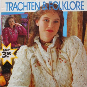 May include: A vintage Diana Sonderheft magazine titled Trachten & Folklore featuring a cream-colored knit cardigan with floral embroidery and gold buttons, a white ruffled collar, and a brown choker with a gold oval pendant on the cover.
