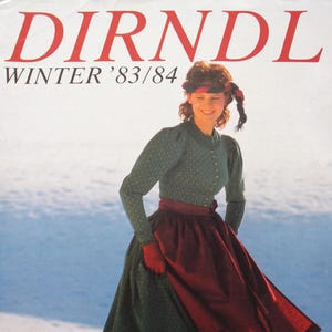 May include: A vintage magazine cover titled DIRNDL WINTER '83/84 featuring a person wearing a green long-sleeved patterned bodice, a dark red apron, and black boots. The text includes 26 MODELLE MIT SCHNITTMUSTERBOGEN ZUM SELBSTSCHNEIDERN.