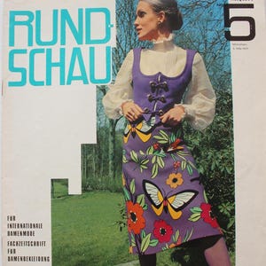 May include: A vintage Rundschau magazine cover from May 1971 featuring a purple sleeveless bodice and matching skirt with a colorful butterfly and floral print. The outfit is paired with a white long-sleeve blouse, purple tights, and purple shoes.