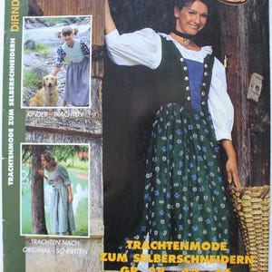 Könnte beinhalten: Ein Dirndl Revue 99 Schnittmuster-Magazin mit einem dunkelgrünen und blauen Kleid und einer weißen Bluse. Das Cover zeigt den Text Dirndl Revue 99, Trachtenmode zum Selberschneidern, Gr. 38-42-46, Kinder 104-140-158, sowie kleine Fotos von Kindern und Erwachsenen in traditioneller Kleidung.