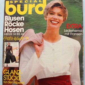 Puede incluir: Una portada de revista con una mujer que lleva una blusa blanca y una falda roja. La revista se titula "burd" y presenta el texto "Blusen Röcke Hosen" y "Herbst-Winter 1990".