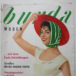 Op de afbeelding: Een vintage tijdschriftcover met een vrouw die een rood-wit gestreepte jurk draagt met een rode hoed en een groene sjaal. Het tijdschrift heet "Burda Moden" en de tekst op de cover luidt: "... mit dem Farb-Schnittbogen Großes REISE-MODE-TOTO Hauptgewinn: 1 AUTO 5/1960 MAI EINZELPREIS DM 1.90 IM ABONNEMENT DM 1.70 zuzüglich Zusteligebühr Osterreich: Einzelpreis 13 Abonnement 5 12-stelgebo Erscheint moлация MODENVERLAG AENNE BURDA OFFENBURG/BADEN 3 Z 2017 E"
