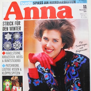 May include: A magazine cover featuring a woman wearing a red sweater with a blue and white pattern. The magazine is titled "Anna" and the cover text says "Strick fur den Winter" which translates to "Knit for the Winter".
