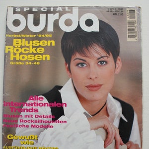 Puede incluir: Una portada de revista con una mujer de pelo corto castaño que lleva una camisa blanca con mangas abullonadas grandes. La revista se titula "burda" y el texto de la portada dice: "Herbst/Winter '94/95 Blusen Röcke Hosen Größe 34-46 Alle internationalen Trends Gewußt wie AUSFÜHRLICHE NÄHTIPS NEUE IDEEN ZUM KOMBINIEREN E 273 WESTEN sportlich, klassisch, modisch".