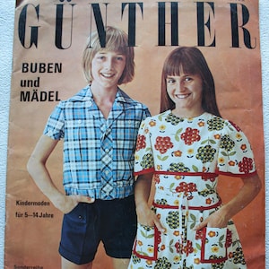 May include: A magazine cover featuring two children modeling clothing. The magazine is titled "Günther Buben und Mädel" and is a special edition for children's fashion. The text on the cover reads "Ausgabe SR D 20779 E" and "Kindermoden für 5-14 Jahre".