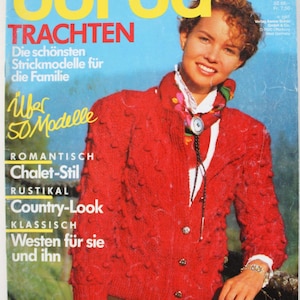 Può includere: Una copertina di rivista con una donna che indossa un cardigan rosso a maglia. La copertina mostra il testo "SPECIAL BURDA TRACHTEN" in giallo e rosso. Ulteriori testi includono "Die schönsten Strickmodelle für die Familie" e "Viele Modelle für Anfängerinnen".