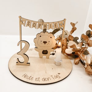 Pu&ograve; includere: Topper per torta di compleanno in legno con un leone, uno striscione che dice "SOPHIE" e il numero "2". Il topper include anche una piccola candela e il testo "Heute ist dein Tag", che si traduce in "Oggi &egrave; il tuo giorno".