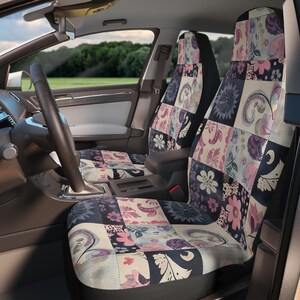 Pode incluir: Um par de capas de assento de carro com um design de patchwork que apresenta padrões florais e paisley em tons de rosa, roxo e azul. As capas são feitas de um tecido macio e confortável e são projetadas para proteger os assentos do seu carro do desgaste.