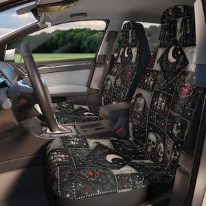 Könnte beinhalten: Autositzbezüge mit Gothic-Thema. Die Bezüge weisen ein Patchwork-Design mit Totenköpfen, Fledermäusen, Monden und Herzen in Schwarz-, Grau- und Rottönen auf. Der Innenraum eines Autos ist sichtbar.
