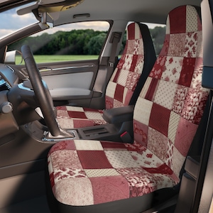 Op de afbeelding: Een paar autostoelhoezen met een patchwork-ontwerp met rode, witte en beige vierkanten. De hoezen hebben een bloemenpatroon en zijn gemaakt van een zachte, comfortabele stof.