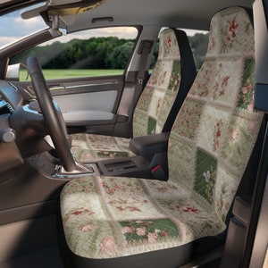 Pode incluir: Um conjunto de duas capas de assento de carro com um design de patchwork que apresenta padrões florais em tons de verde, rosa e beige. As capas são feitas de um tecido macio acolchoado e têm um suporte preto.