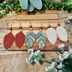 Peut inclure: Quatre paires de boucles d'oreilles en forme de feuille crochetées avec des perles en bois. Les boucles d'oreilles sont en rouge, bleu, vert et blanc.